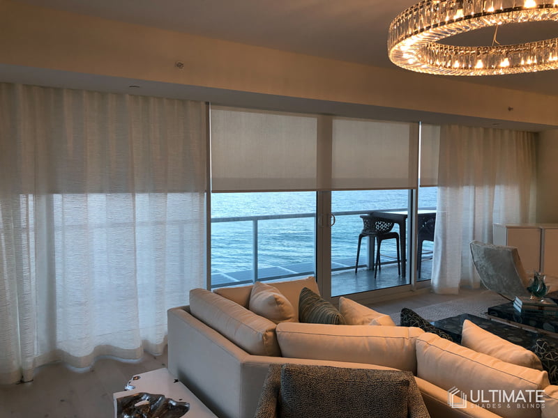 drapery with blinds in living room with ocean view